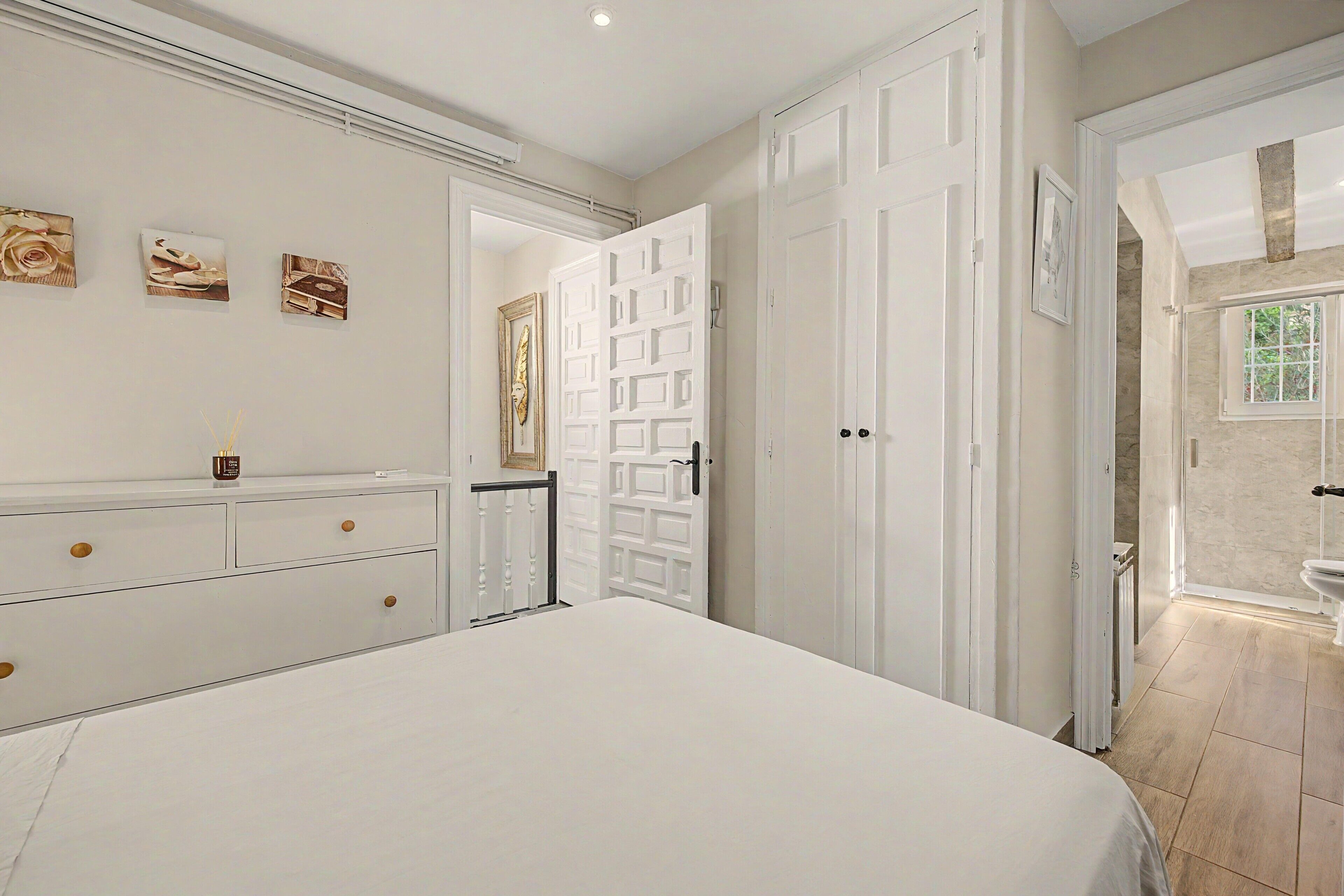 Een slaapkamer met een groot bed, een kaptafel en een deur naar een badkamer.