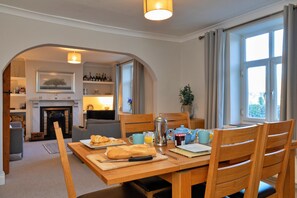 A dining area with a table set for breakfast, including croissants and a hot beverage. - Cottage in Peak District National Park (Macclesfield)