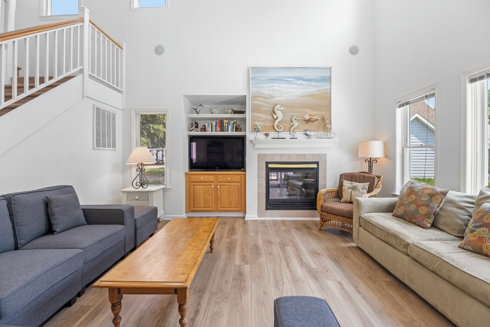 A spacious living room with a fireplace, a television, and a bookshelf.