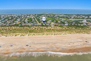 An aerial view of a coastal residential area with houses, a beach, and a body of water. - Yellow Submarine: Oceanfront | Hot Tub, Deck (Salvo)