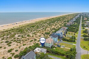 Zona residencial costera con casas, una playa y una carretera.