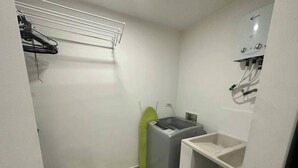 Un lavadero pequeño con lavadora, secadora y lavabo.