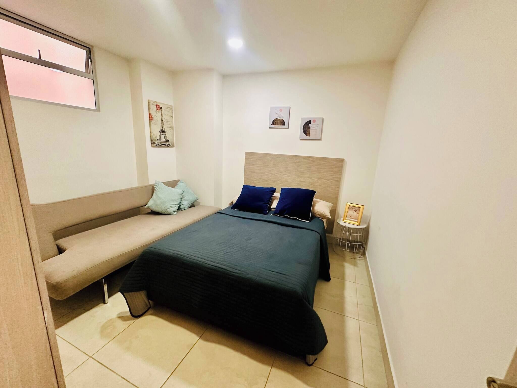Une chambre à coucher avec un lit, un banc et une petite table.