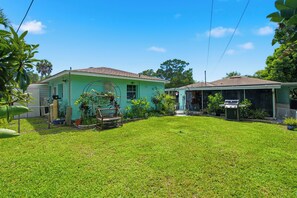 A residential property with a well-maintained lawn, a patio area, and a variety of potted plants. - Relax on the Grand River! Bright Waterfront Home (New Port Richey)
