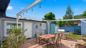 A patio with a table and chairs, a grill, and a covered area with string lights. - Newly Remodeled Home 1 Mi to Dtwn New Port Richey (New Port Richey)