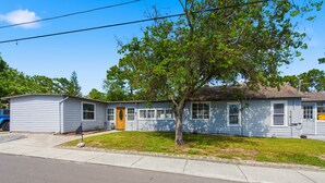 A single-story house with a front yard, a driveway, and a street view. - Newly Remodeled Home 1 Mi to Dtwn New Port Richey (New Port Richey)