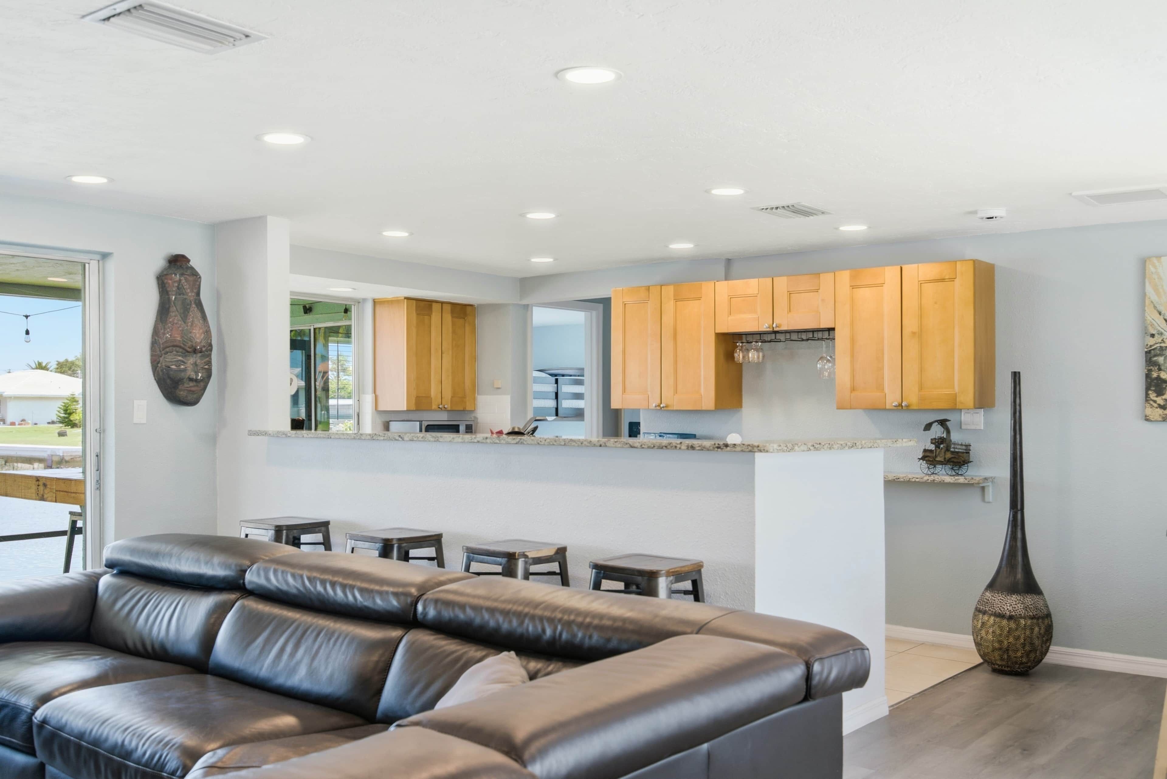 A modern kitchen with wooden cabinets, a countertop, and a large vase.