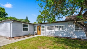 A single-story house with a front porch, a garage, and a small front yard. - Updated Studio 1 Mi to Dtwn NPR & Cotee River! (New Port Richey)