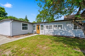 Ein eingeschossiges Haus mit Veranda, Garage und kleinem Vorgarten.