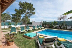 A backyard with a swimming pool, green lounge chairs, and a small garden area. - Villa Tintoretto - Four Bedroom Villa, Sleeps 8 (Mallorca)