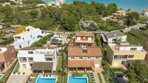 Ett bostadsområde med flera hus, en swimmingpool och utsikt över havet.