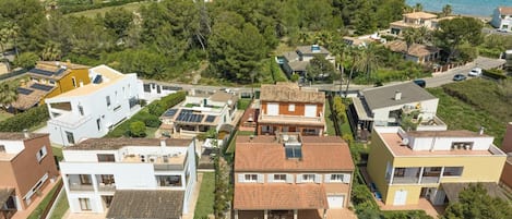 A residential area with multiple houses, a swimming pool, and a view of the sea.