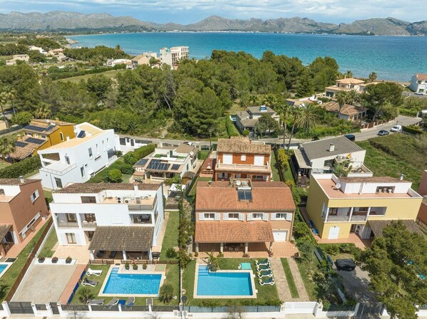 A residential area with multiple houses, a swimming pool, and a view of the sea. - Villa Tintoretto - Four Bedroom Villa, Sleeps 8 (Mallorca)