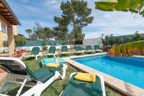 Área da piscina com espreguiçadeiras e uma piscina pequena.