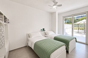 Habitació amb dos llits, un ventilador de sostre i vista exterior.