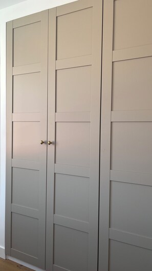 A closed double door with a simple design and a brass handle. - Fully renovated apartment. Perfect for a couple. Close to amenities, the beach, and a park. (Arcachon)