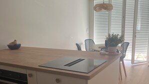 Eine moderne Küche mit Backofen, Holzarbeitsplatte und einem Essbereich mit Stühlen und einem Tisch.