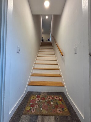 Un escalier avec des marches en bois et une rampe en bois, menant à l’étage supérieur.