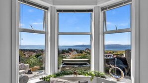 Ein Erker mit Blick auf eine Küstenstadt und das Meer.