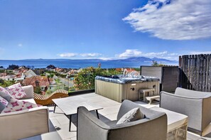 A rooftop terrace with outdoor seating, a hot tub, and a view of the sea and mountains. - Charming Devon Cottage With Garden (West Kilbride)