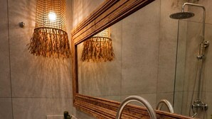 A bathroom with a large mirror, a white sink, a shower, and a candle on the counter. - Charming 2-bedroom house with AC in adorable Chascomús (Chascomús)