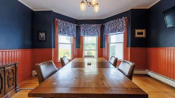 Un salón de conferencias con una mesa de madera, sillas y una araña.