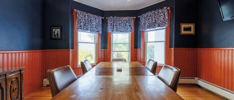 A conference room with a wooden table, chairs, and a chandelier.