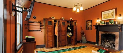 Una habitación con mesa de billar, chimenea y un conjunto de puertas de madera.