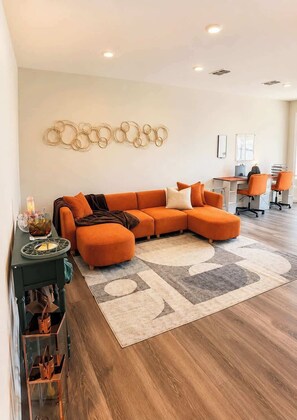 Een moderne woonkamer met een hoekbank, een salontafel en een vloerkleed.