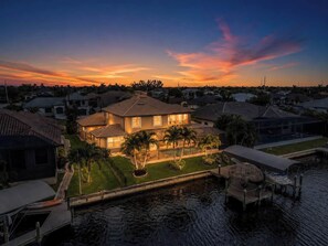 Ein Wohnhaus mit Swimmingpool, Bootsanleger und gepflegtem Rasen.