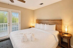 Une chambre à coucher avec un grand lit, deux lampes de chevet et une tête de lit en bois.