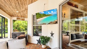 A modern interior with a large window, a sofa, a potted plant, and a decorative star. - Naples Luxury Home, Resort Pool, Lanai, Fire Table (Naples)