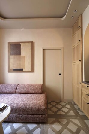Ein Zimmer mit einer Couch, einer Tür und Schränken.