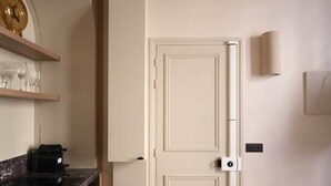 A kitchen with a marble countertop, a built-in oven, and a double door with a light switch. - Architect-designed apartment near Beaugrenelle (Paris)