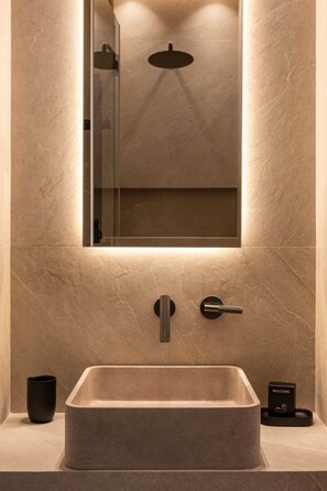 A bathroom with a rectangular sink, a mirror, and a 'Welcome' sign. - Elegant Studio in the Vendôme - Madeleine Area (Paris)