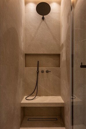 A modern shower with a handheld showerhead, a handheld shower attachment, and a built-in seat. - Elegant Studio in the Vendôme - Madeleine Area (Paris)