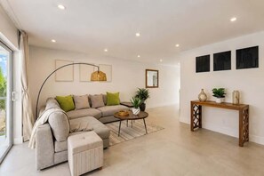 Ein modernes Wohnzimmer mit einem Ecksofa, einem Couchtisch und einem Konsolentisch mit Dekoration.