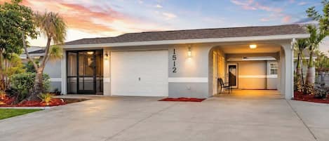 A modern two-story house with a garage, a covered entryway, and a well-maintained front yard.