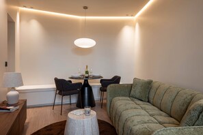 Ein modernes Wohnzimmer mit einem runden Couchtisch, einer Couch und einem Essbereich mit Stühlen und einem Tisch.