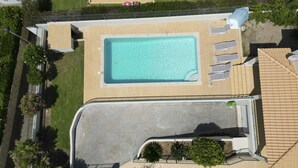 An aerial view of a property with a swimming pool, a covered parking area, and a landscaped garden. - #416 Spacious Villa | Private Pool, BBQ, and Parking (Albufeira)