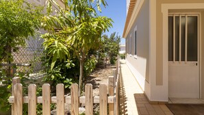 A residential property with a wooden fence, a pathway, and a building with a white door. - #416 Spacious Villa | Private Pool, BBQ, and Parking (Albufeira)