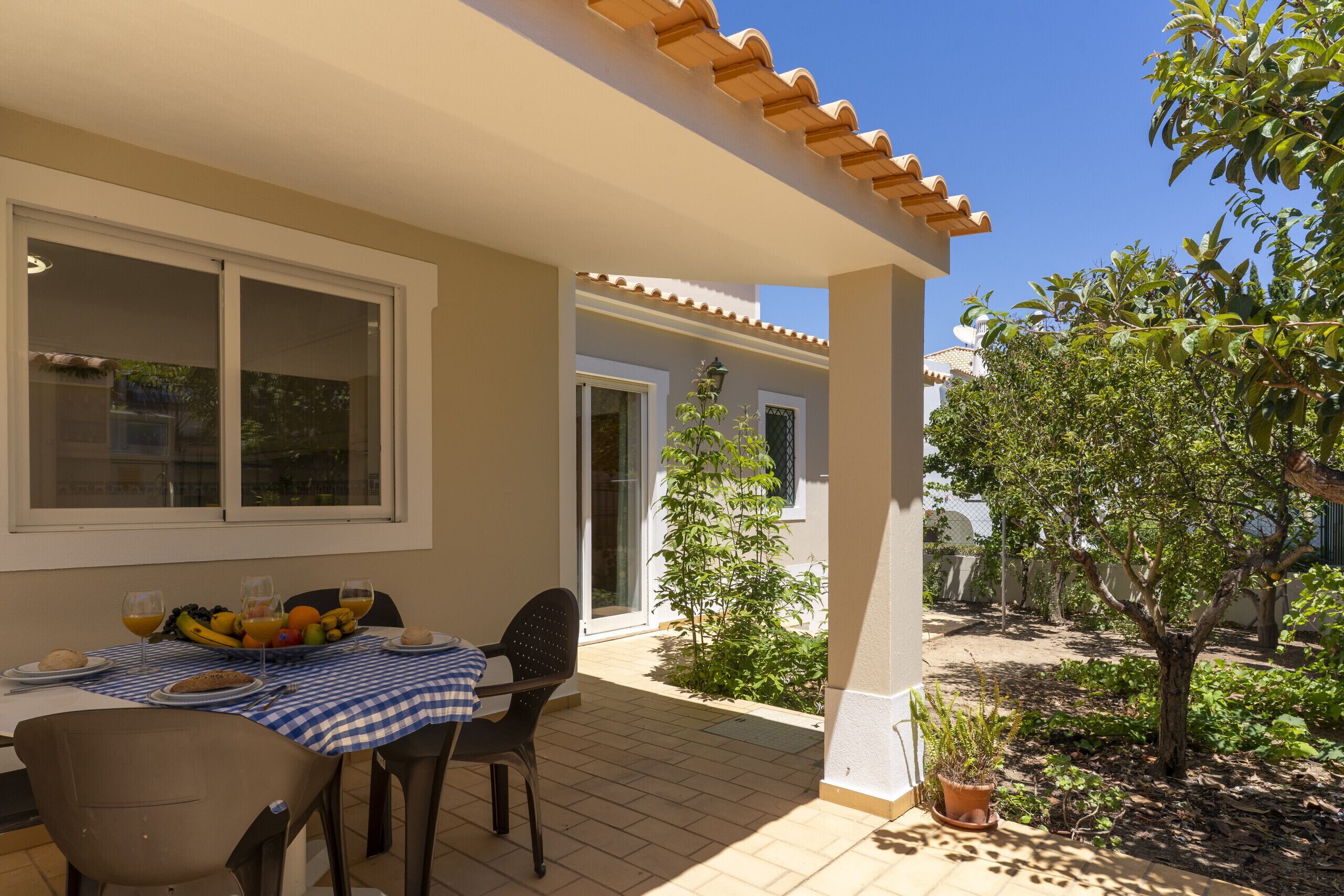 Eine Terrasse im Freien mit Esstisch, einem Stuhl und einem Blumentopf.