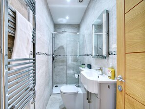A modern bathroom with a glass-enclosed shower, a white toilet, and a vanity with a mirror. - Harrogate Apartment Near Bettys (Harrogate)