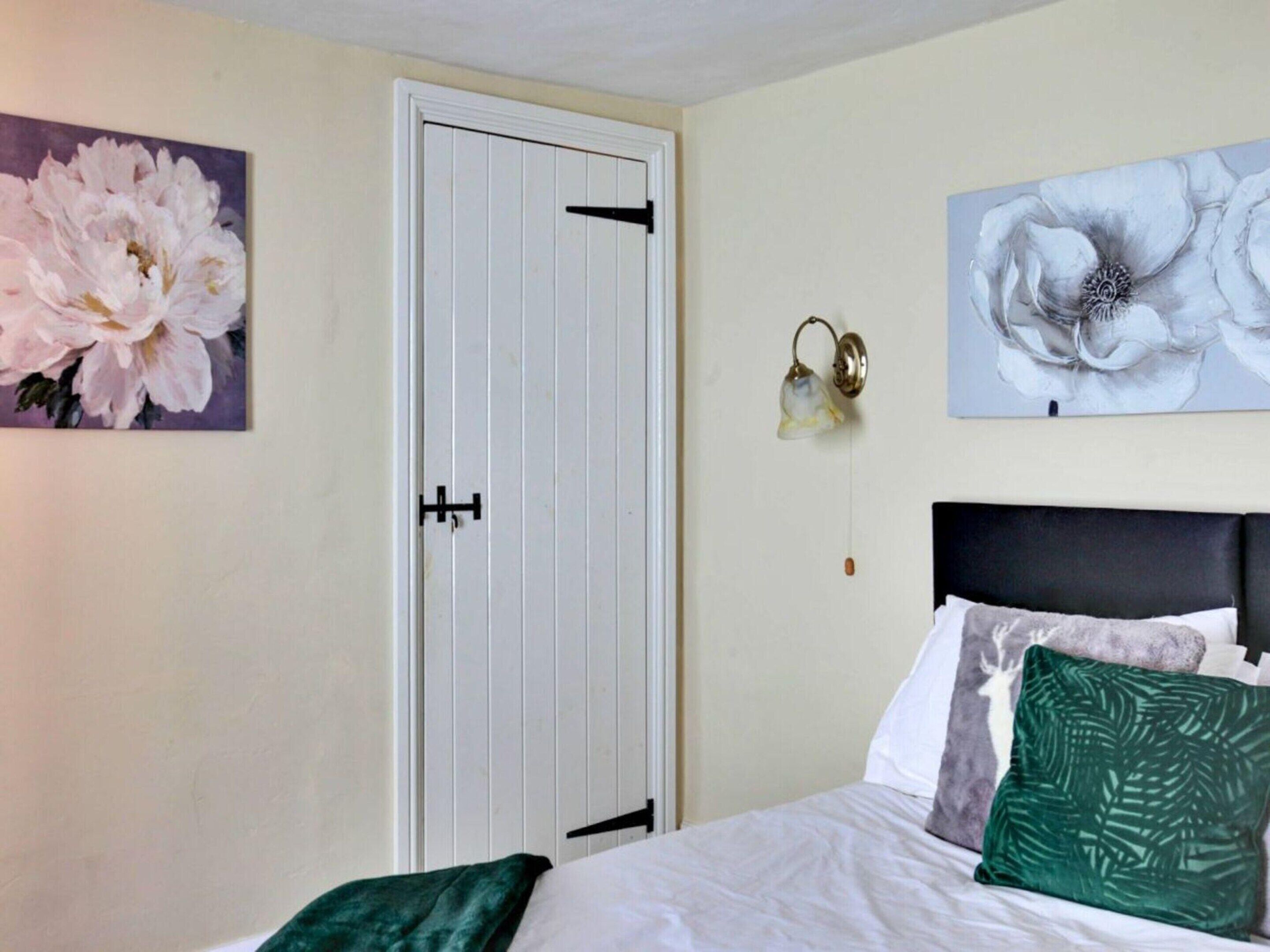 Une chambre à coucher avec un lit, une porte et deux appliques murales.