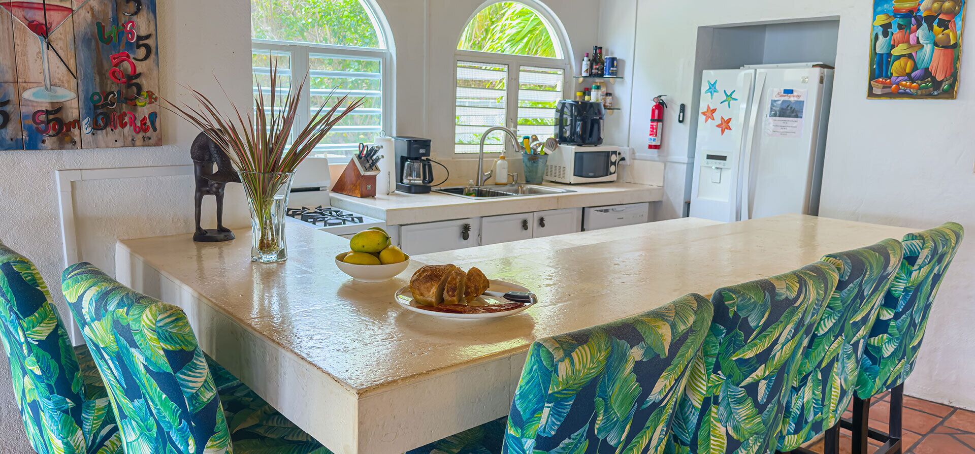 A kitchen with a central island, a coffee maker, and a refrigerator.