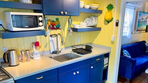 A compact kitchen with a microwave, sink, and blue cabinets. - Beautiful Private Waterfront Estate, 2 Properties, 4 Bedrooms, West End Tortola (Tortola)