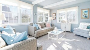 A well-lit living room with a sofa, armchairs, and a coffee table. - Charming Seaside Retreat – Walk to the Beach in Rye, NH (Rye)