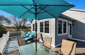 A deck with a glass table, chairs, and a blue umbrella. - Charming Seaside Retreat – Walk to the Beach in Rye, NH (Rye)