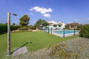 Una propiedad residencial con piscina, césped y una casa con antena parabólica.