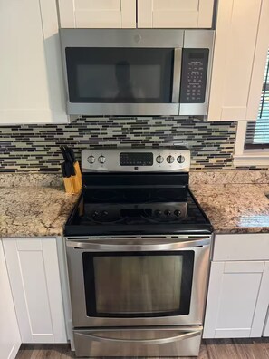 A kitchen with a stainless steel stove, oven, and microwave. - Executive 4BR Home Fully Furnished. CALL IT HOME 30+Day (Louisville)